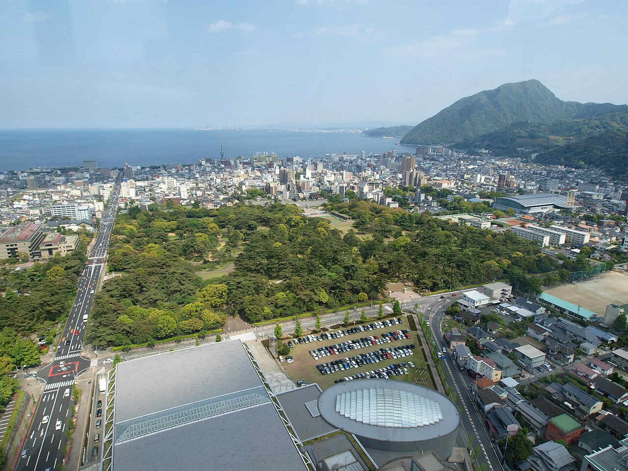 高い位置から見た別府公園の森と園路、別府の街と海。2010年5月の写真。