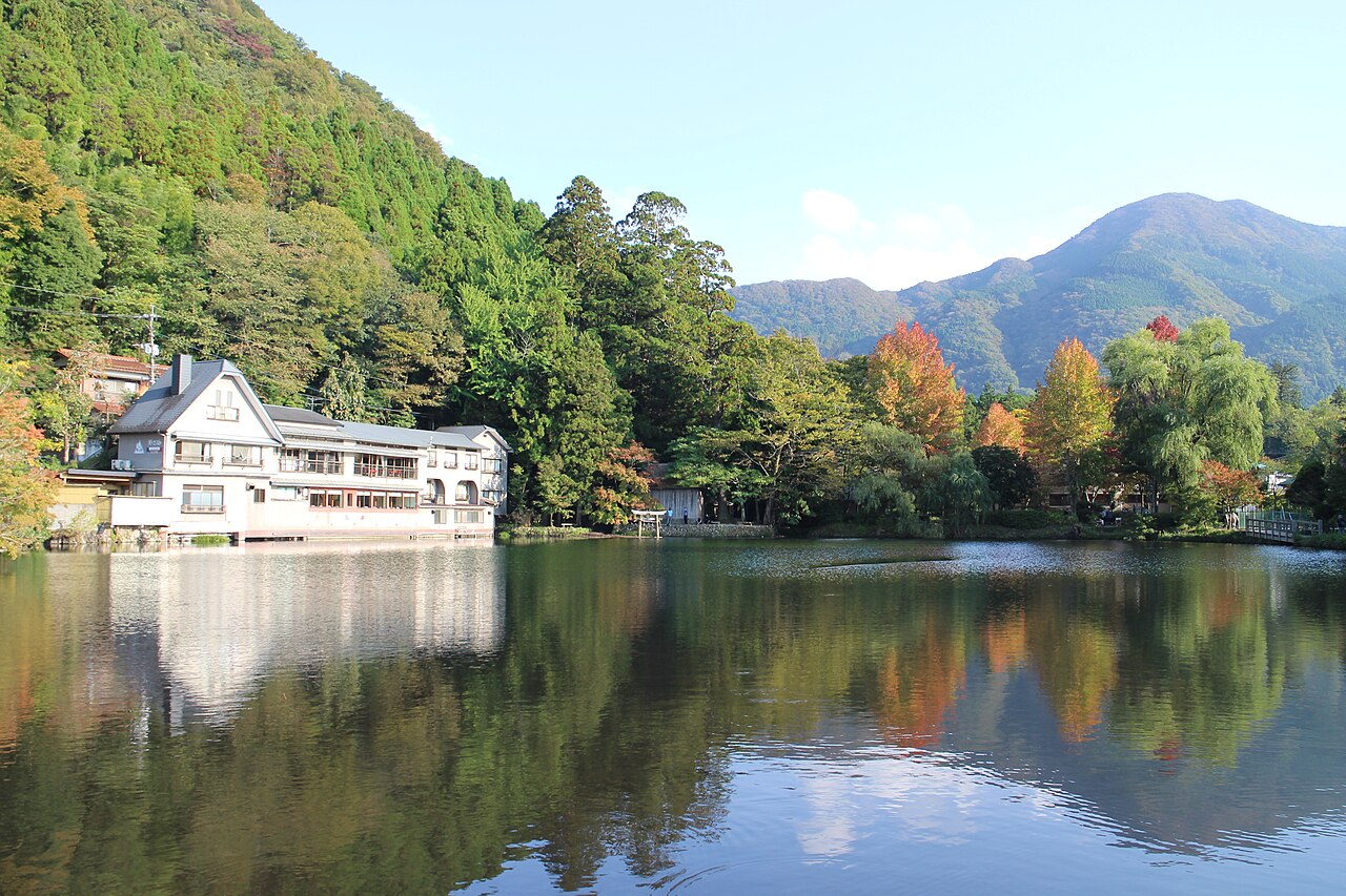 金鱗湖の湖面と色づき始めた木々、背後の山。2022年10月22日の写真。