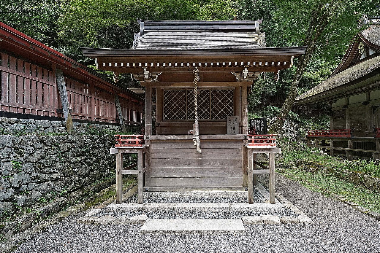 日吉大社境内の小社と、周囲の社殿や緑の木々。緑の時期の風景
