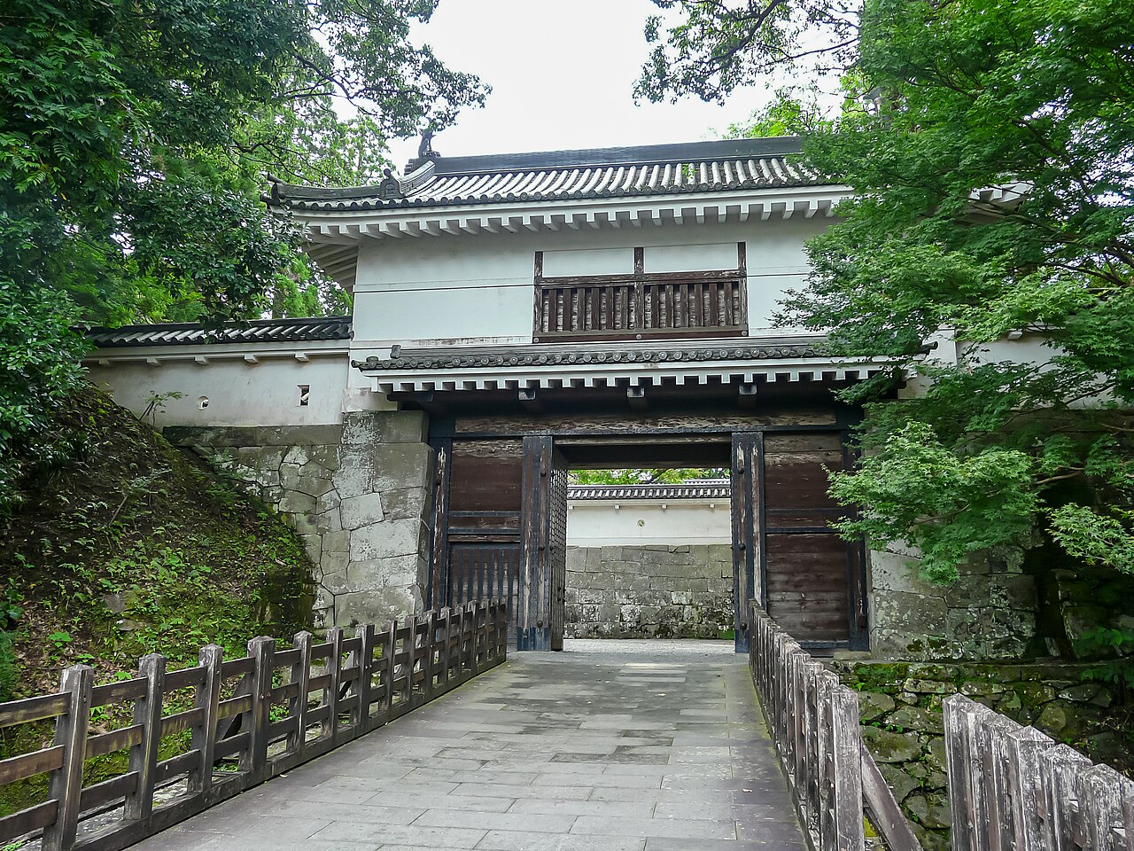 木々に囲まれた飫肥城大手門と石垣。2019年8月撮影。