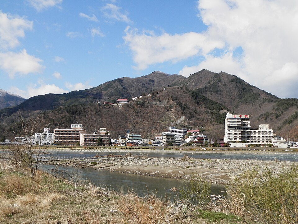 千曲川の対岸に戸倉上山田温泉の建物と山が見える。