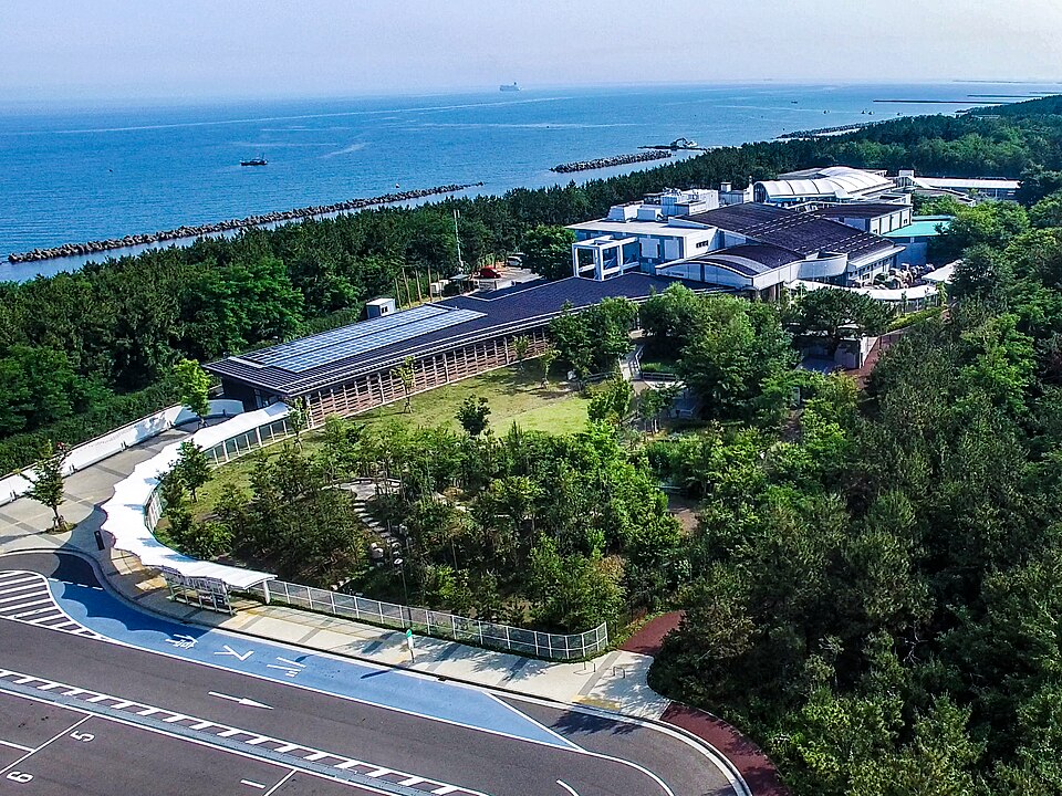 海辺の緑に囲まれたマリンピア日本海を上空から望む。