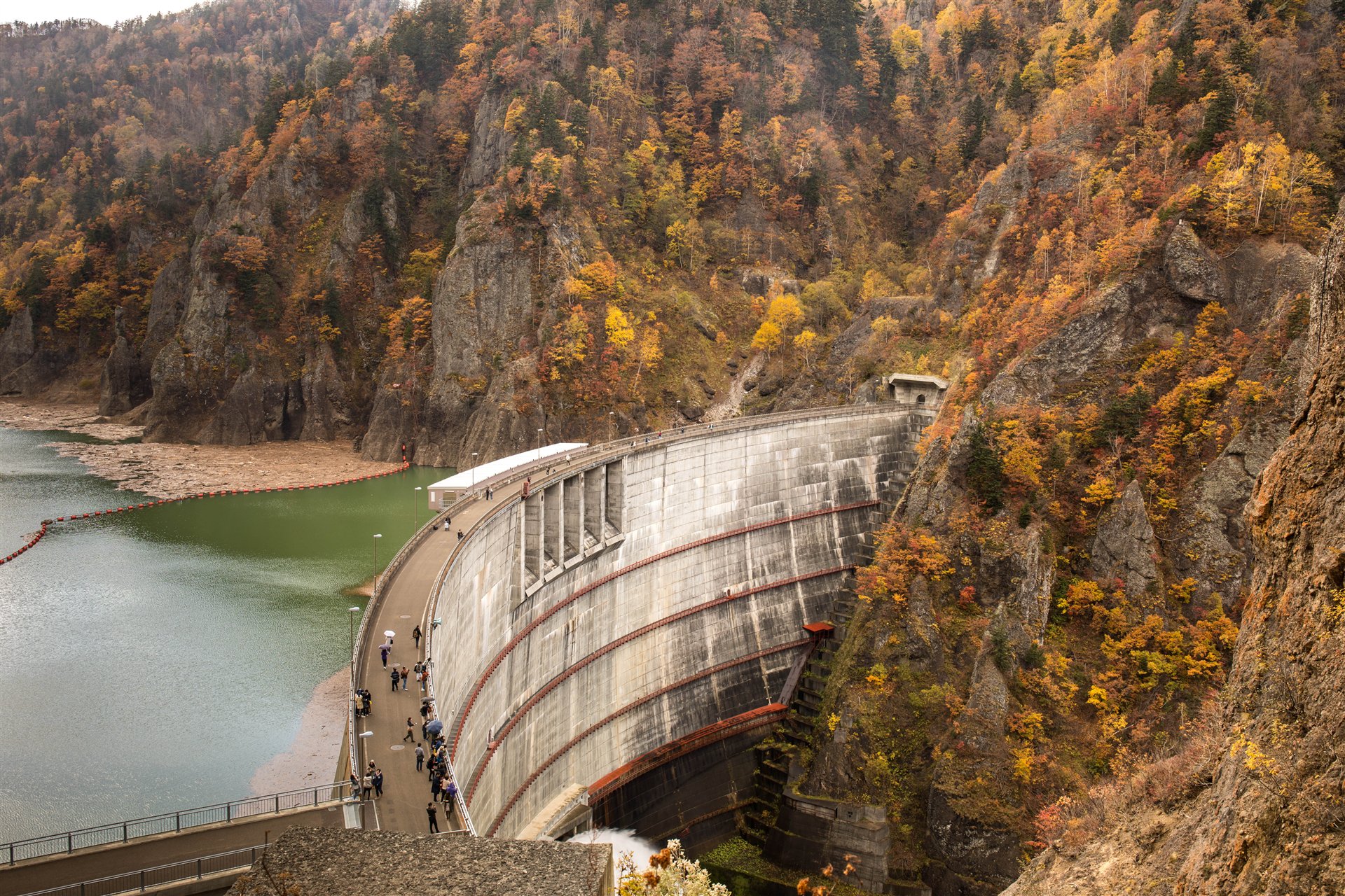 紅葉した山々と豊平峡ダムの堤体。