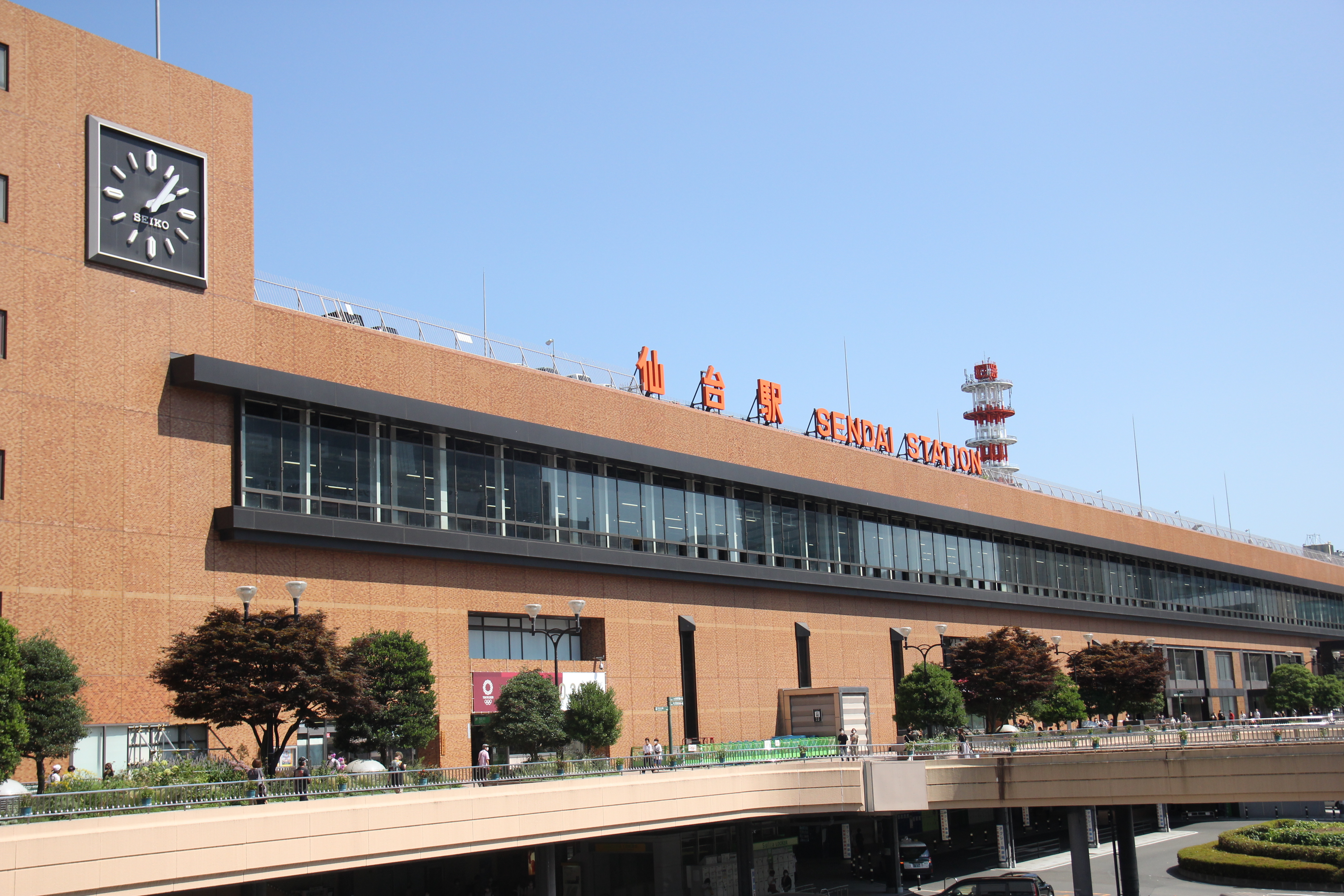 仙台駅西口の時計と駅名がある駅舎、手前の歩行者デッキ