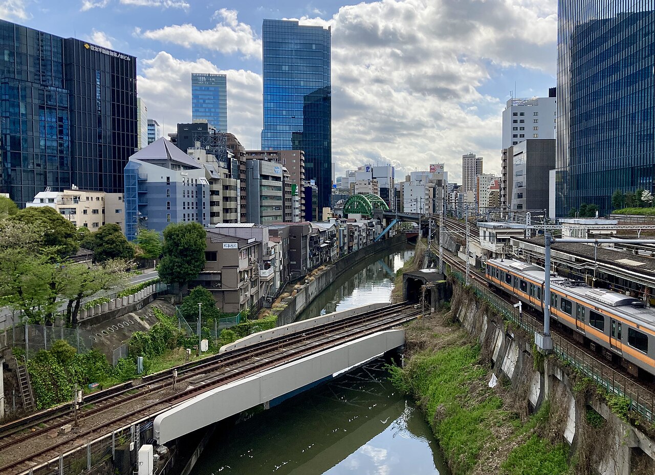 聖橋から見る神田川。川の脇を中央線の列車が走り、手前を線路橋が渡る。