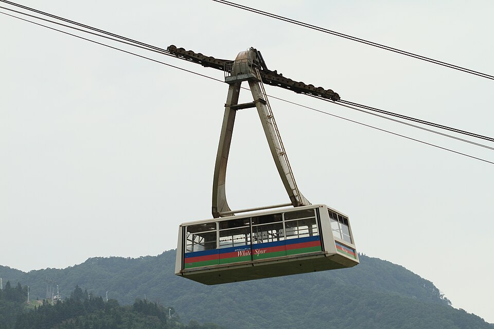 緑の山を背に、湯沢高原ロープウェイの客車が進む。